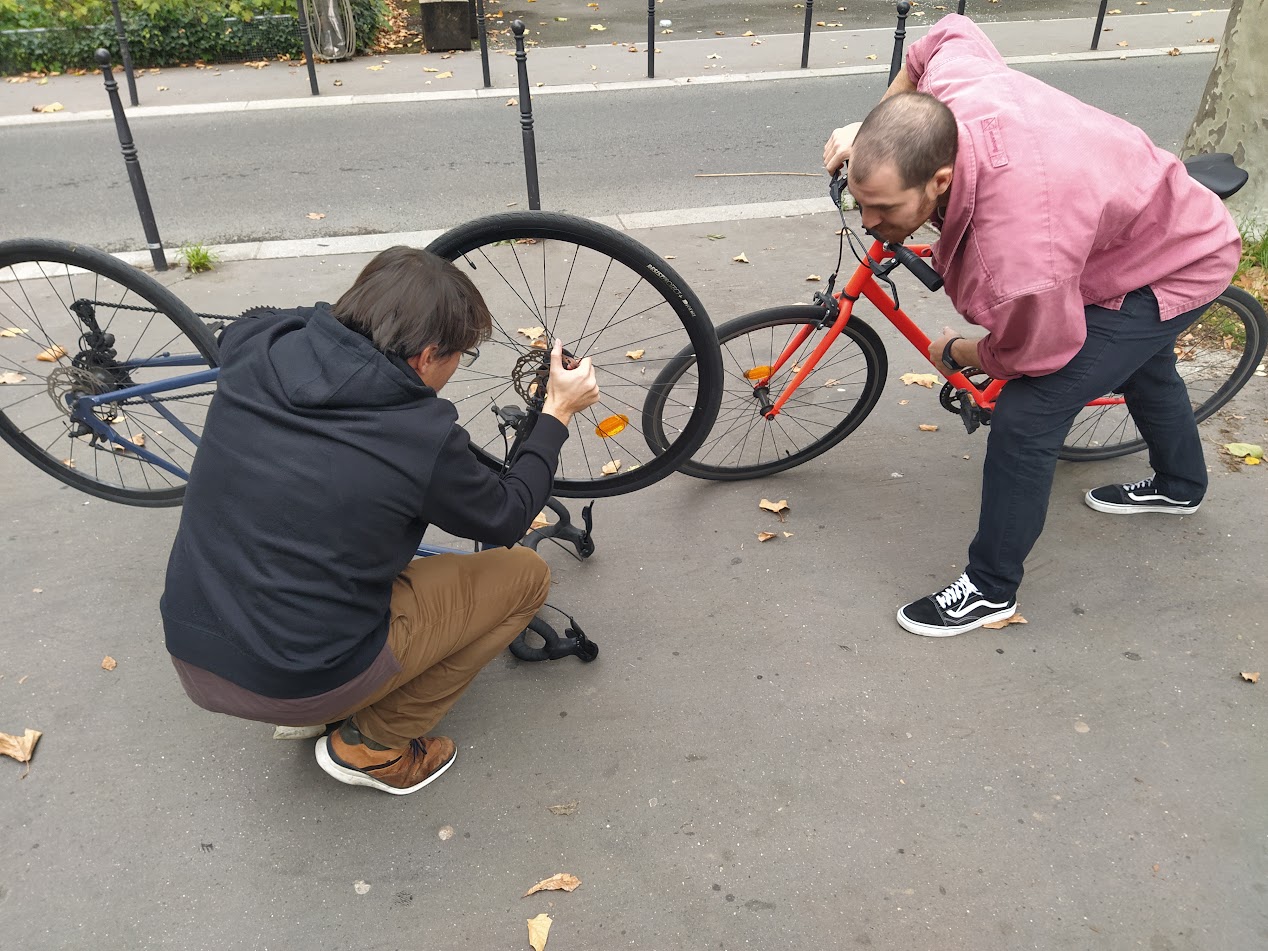 Franck Risberrypi qui aide Samuel Osintiti à réparer sa roue